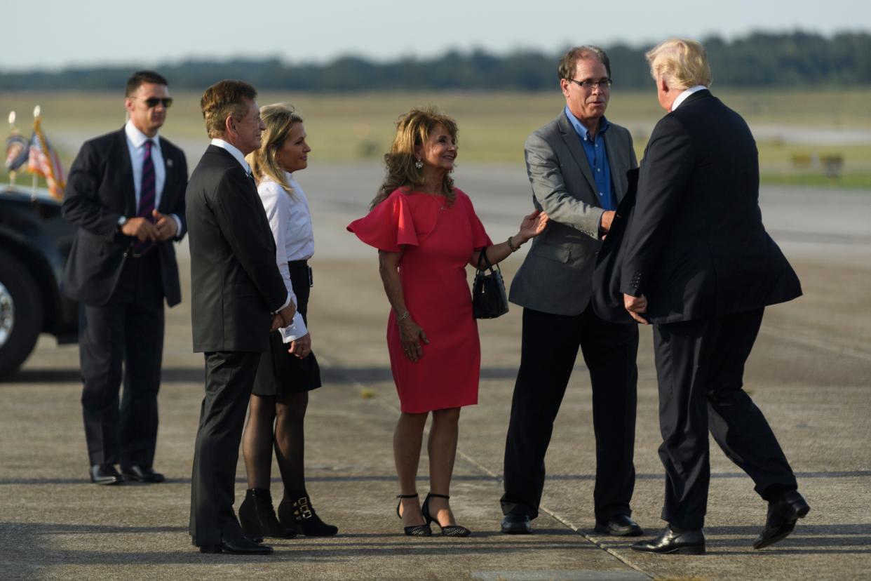 After disembarking Air Force One, President Donald Trump, from right, is greeted by U.S. Senate candidate Mike Braun, Maureen Braun, Terri Chancellor and Steve Chancellor at the Evansville Regional Airport in Evansville, Ind., Thursday, Aug. 30, 2018. 