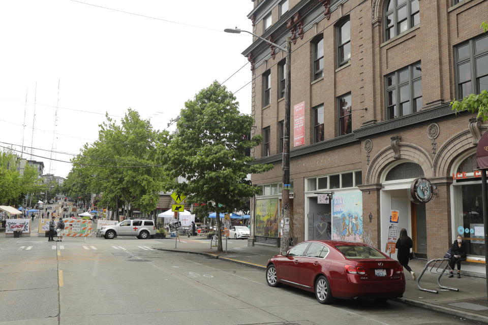 The Oddfellows Hall is shown at right, Saturday, June 20, 2020, at the intersection of 10th Ave. and Pine St. next to a barricade for the Capitol Hill Occupied Protest zone in Seattle. A pre-dawn shooting near the area left one person dead and critically injured another person, authorities said Saturday. The area has been occupied by protesters after Seattle Police pulled back from several blocks of the city's Capitol Hill neighborhood near the Police Department's East Precinct building. (AP Photo/Ted S. Warren)