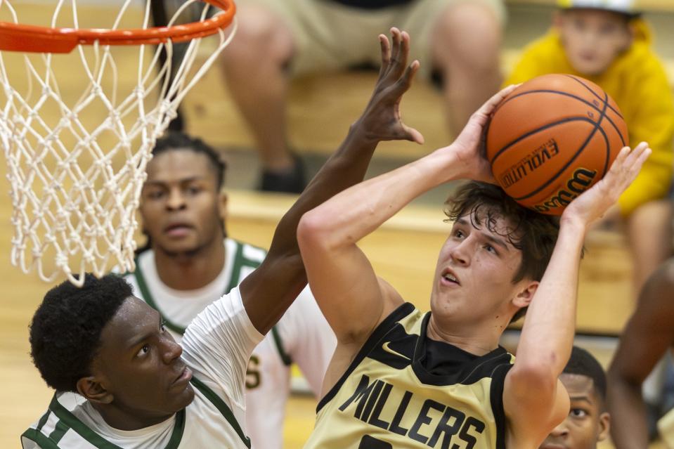 Indianapolis Crispus Attucks High School junior Chris Hurt (1) attempts to block a shot by Noblesville High School senior Hunter Walston (24) during the second half of an IHSAA basketball game, Saturday, Dec. 9, 2023, at Southport High School in the Forum Tipoff Classic.