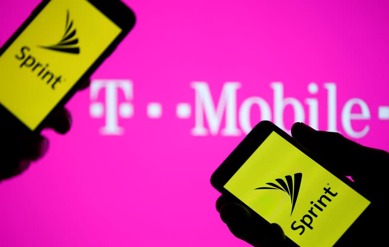 A smartphones with Sprint logo are seen in front of a screen projection of T-mobile logo, in this picture illustration