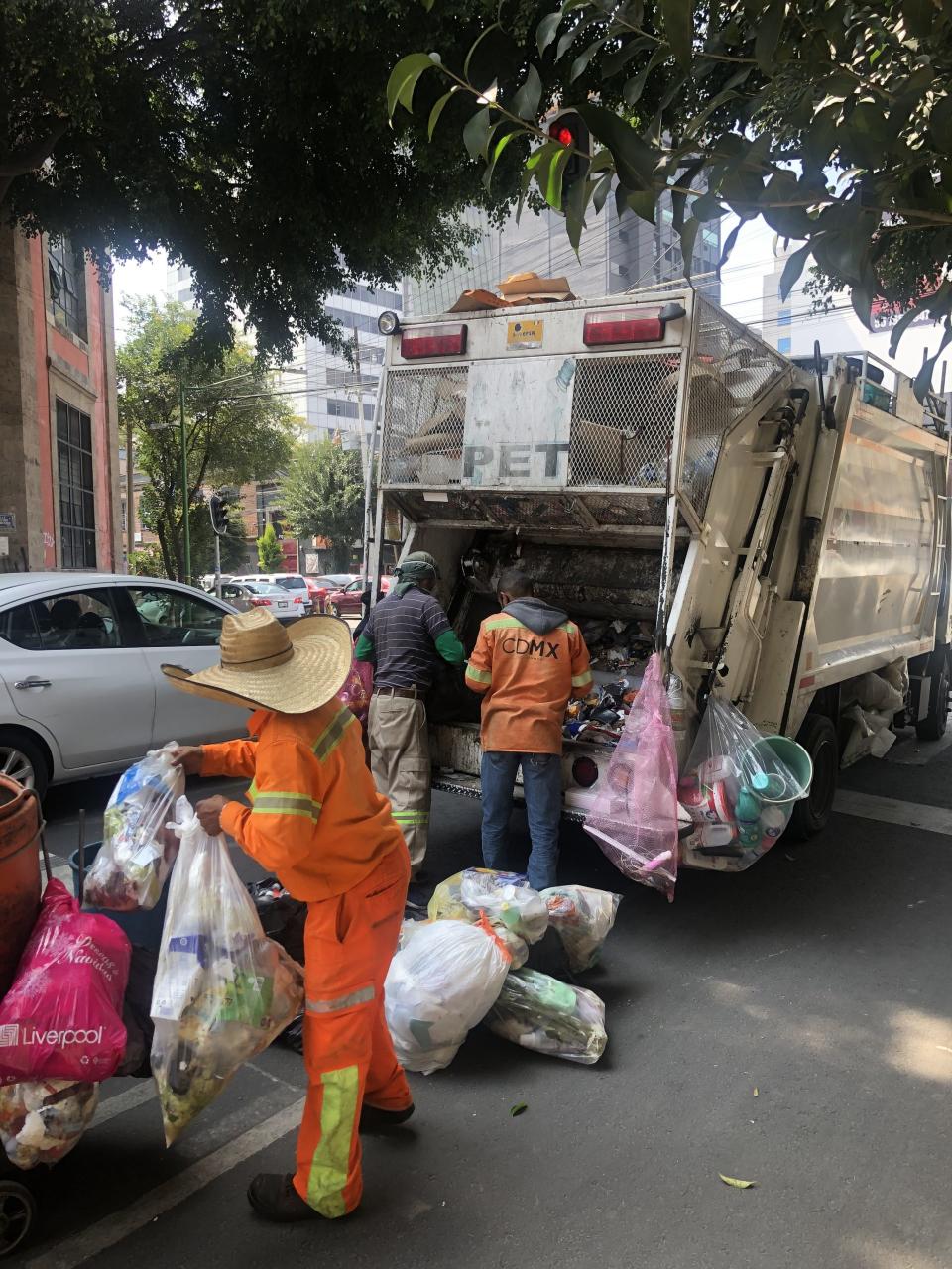Muchos barrenderos recogen la basura casa por casa y la llevan al camión recolector. Foto: Claudia Altamirano.