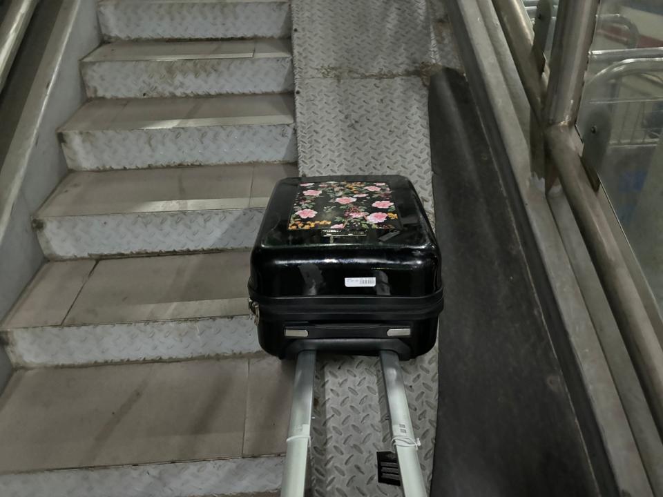 Luggage rolling down staircase at Hanoi Railway Station.