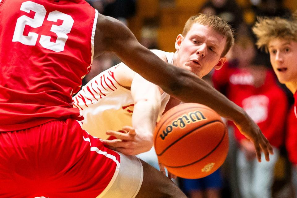 Fishers' Taden Metzger (2) gets a pass around Crown Point's Dikembe Shaw (23) during the Fishers vs. Crown Point boys semistate basketball semifinal game Saturday, March 16, 2024 at Northside Gym in Elkhart.