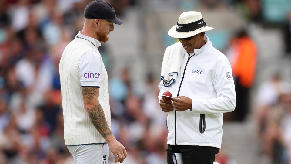 Ben Stokes looks on as umpire Joel Wilson checks the condition of the ball in the fifth Ashes Test.