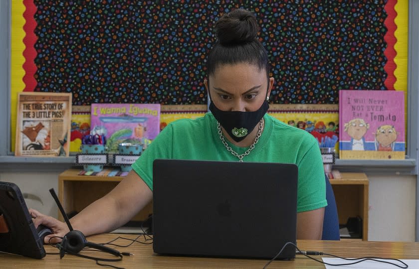 LOS ANGELES, CA -AUGUST 19, 2020: Gladys Alvarez, a 5th grade teacher at Manchester Ave. Elementary School in South Los Angeles, talks to her students during a meet and greet on Wednesday afternoon. Alvarez was sitting inside her empty classroom while conducting the virtual zoom class. (Mel Melcon / Los Angeles Times)