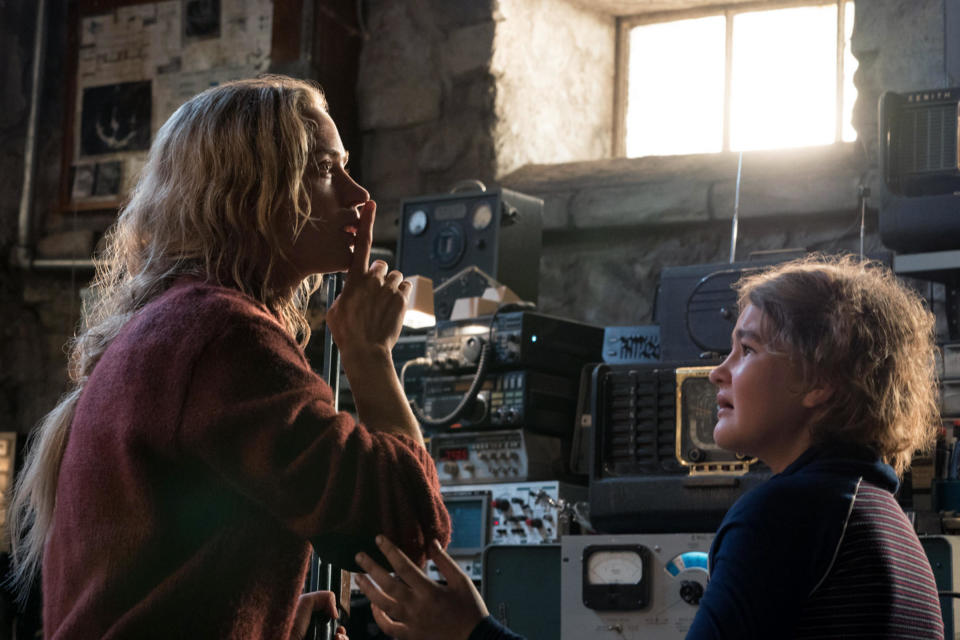 A woman attempts to hush her daughter near radio equipment in a basement