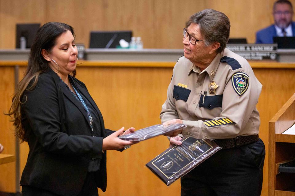 DASO Sheriff Kim Stewart, right, hands employee Lucy Narvaez, left, a plaque during the Board of County Commissioners meeting on Tuesday, Nov. 28, 2023, at the Doña Ana County Government Building.