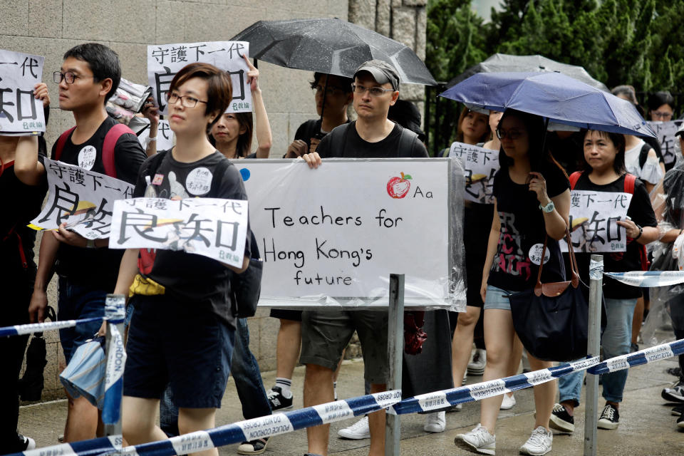 Pro-democracy protesters march organized by teachers in Hong Kong Saturday, Aug. 17, 2019. Members of China's paramilitary People's Armed Police marched and practiced crowd control tactics at a sports complex in Shenzhen across from Hong Kong in what some interpreted as a threat against pro-democracy protesters in the semi-autonomous territory. (AP Photo/Vincent Yu)