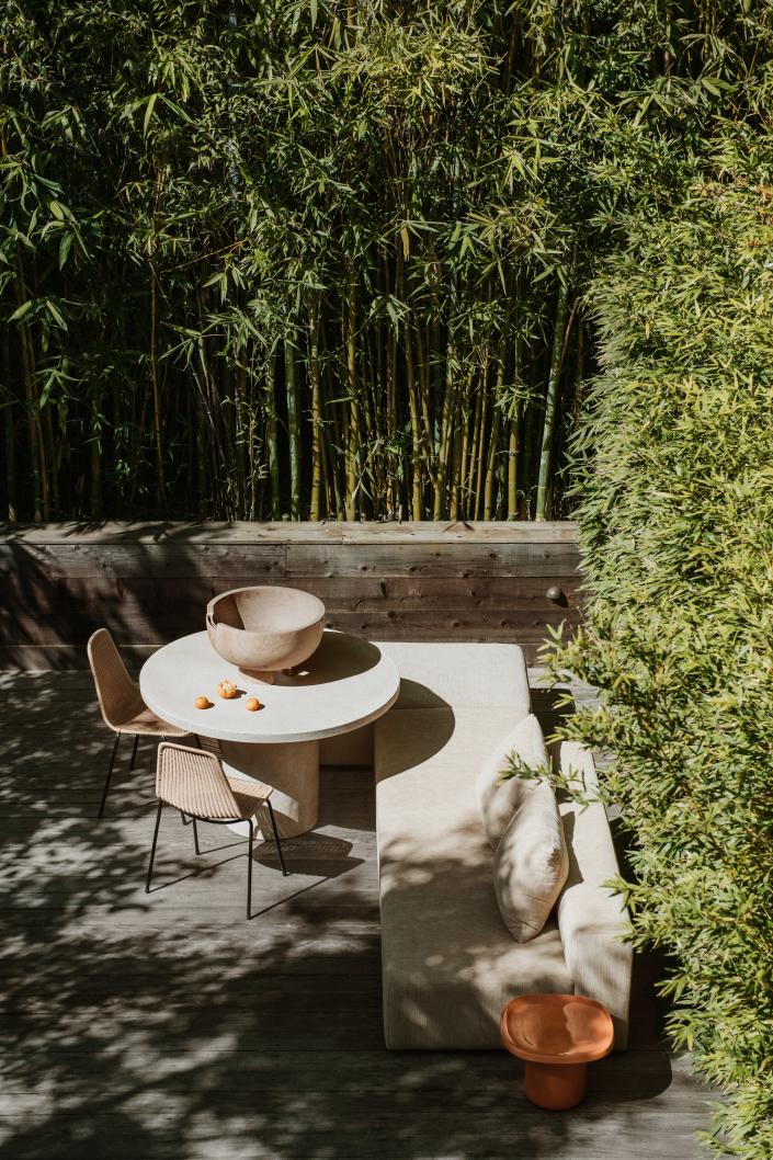 The dreamy and lush backyard space is surrounded by bamboo.