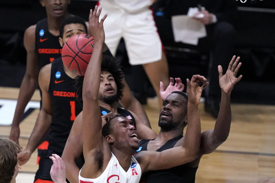 Houston forward Fabian White Jr. loses the ball while driving to the basket in front of Oregon State forward Dearon Tucker, right, during the first half of an Elite 8 game in the NCAA men's college basketball tournament at Lucas Oil Stadium, Monday, March 29, 2021, in Indianapolis. (AP Photo/Michael Conroy)