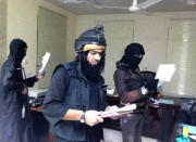 FILE - This undated file image posted on a militant website on Jan. 4, 2014, which is consistent with other AP reporting, shows Shakir Waheib, center, a leader in the al-Qaida-linked Islamic State of Iraq and the Levant (ISIL), searching a government office in Ramadi, Anbar Province, Iraq. The ISIL led by Abu Bakr al-Baghdadi is the main driver of destabilizing violence in Iraq and until recently was the main al-Qaida affiliate there. Al-Qaida’s general command formally disavowed the group this week, saying it "is not responsible for its actions." (AP Photo via militant website, File)