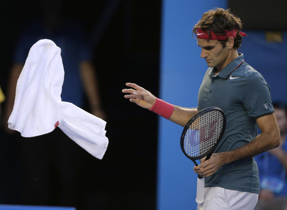 Roger Federer of Switzerland throws a towel as he plays Andy Murray of Britain during their quarterfinal at the Australian Open tennis championship in Melbourne, Australia, Wednesday, Jan. 22, 2014.(AP Photo/Rick Rycroft)