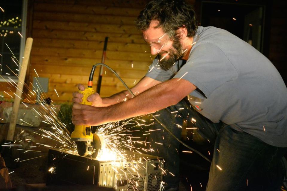 Josh “Za” Wilcox wields an angle grinder to destroy a computer used to generate parameters for Zcash.