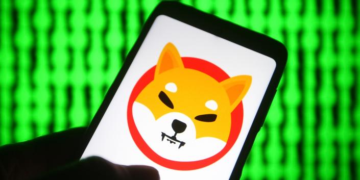 In this photo illustration, a cryptocurrency Shiba Token $SHIB logo is seen on a smartphone with a pc screen in the background.