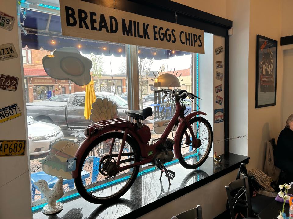 A moped from Valley Vintage Motorworks helps set the vibe in the storefront window at Hash N Smash.