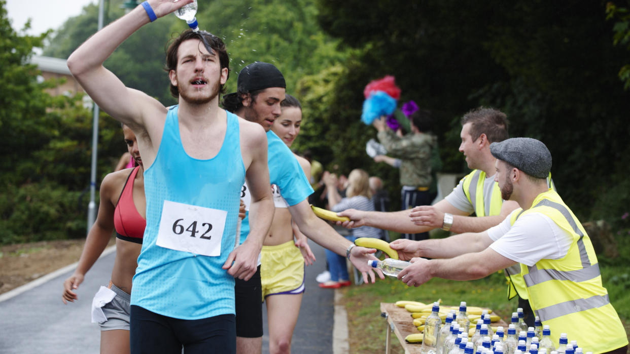  Runners taking water and bananas from aid station during a race. 