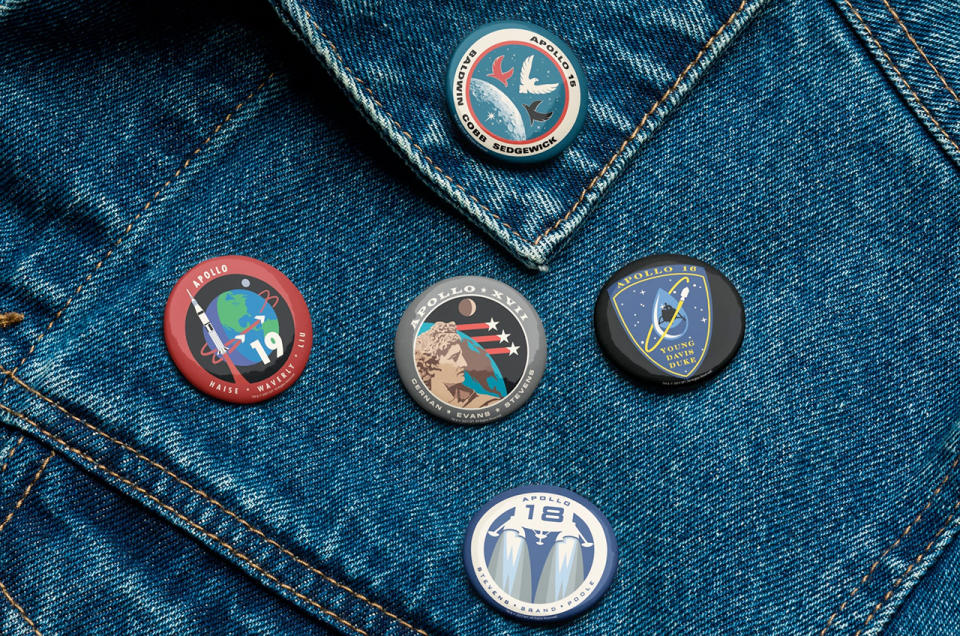 closeup of a denim jacket adorned with five small, circular buttons.
