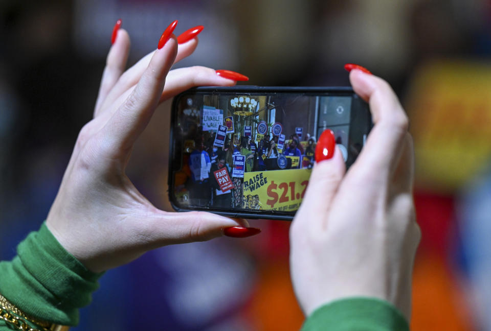 Supporters document protesters urging lawmakers to raise New York's minimum wage during a rally at the state Capitol, Monday, March 13, 2023, in Albany, N.Y. (AP Photo/Hans Pennink)