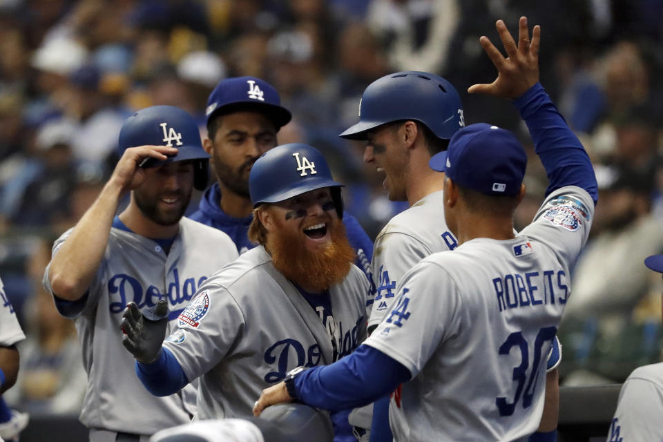 Los Angeles Dodgers' Justin Turner (10) celebrates with manager Dave Roberts (30) after hitting a two-run home run during the eighth inning of Game 2 of the National League Championship Series baseball game against the Milwaukee Brewers Saturday, Oct. 13, 2018, in Milwaukee. (AP Photo/Jeff Roberson)