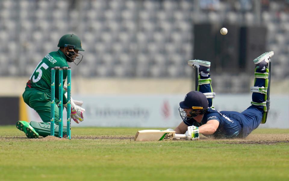 Jos Buttler dives to make his ground - Aijaz Rahi/AP