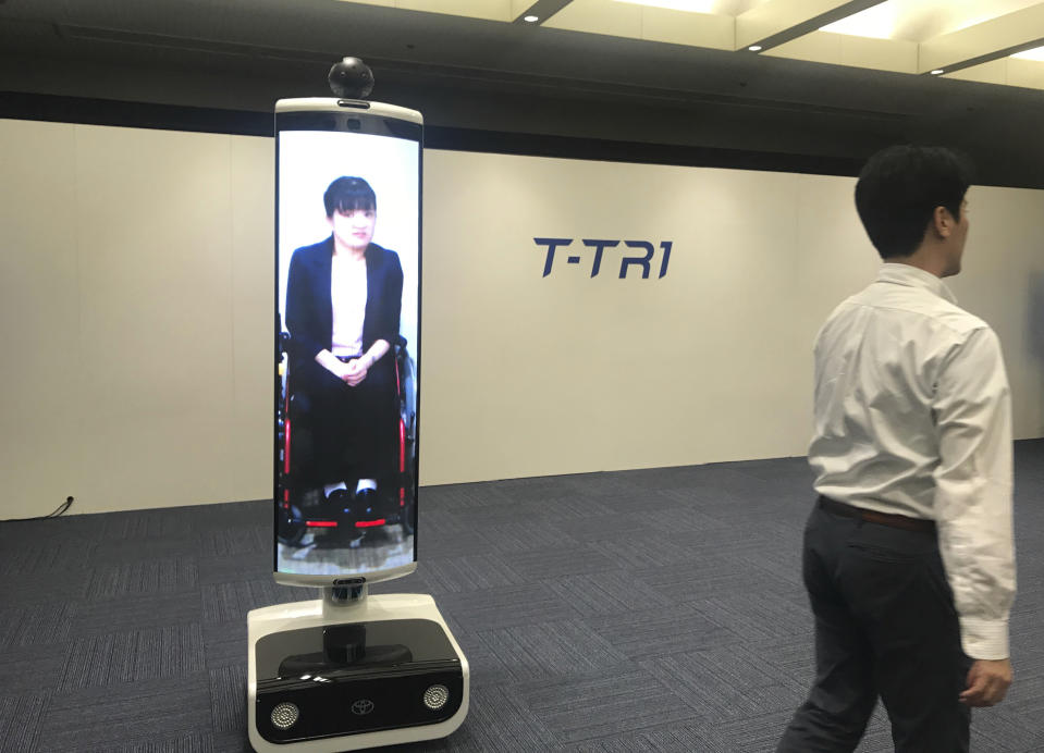 In this Thursday, July 18, 2019, photo, a T-TRI robot is demonstrated before the media at Toyota Motor Corp. headquarters in Tokyo. The Japanese automaker Toyota, a major Olympic sponsor, is readying various robots for next year’s Tokyo Olympics, including the screen-on-wheels designed for "virtual" attendance. The T-TR1 is a moving human-size display designed to represent people who can't be there. (AP Photo/Yuri Kageyama)