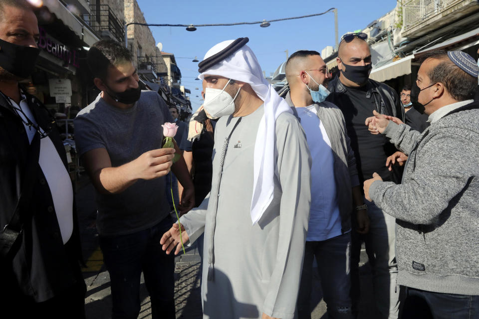 An Israeli man handed a flower to Emirati singer Walid Aljasim, during his visit in Jerusalem, Thursday, Dec. 3, 2020. (AP Photo/Mahmoud Illean)