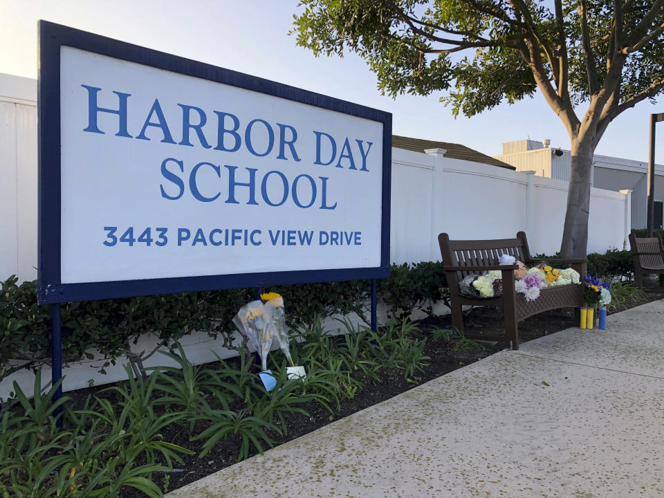 Flowers and messages are placed in front of Harbor Day School, a private elementary school in Corona Del Mar, Calif., Monday, Jan. 27, 2020. Christina Mauser, a girls basketball coach at the school, was among those killed in the helicopter crash that took the lives of former Lakers star Kobe Bryant and seven others Sunday. (AP Photo/Amy Taxin)