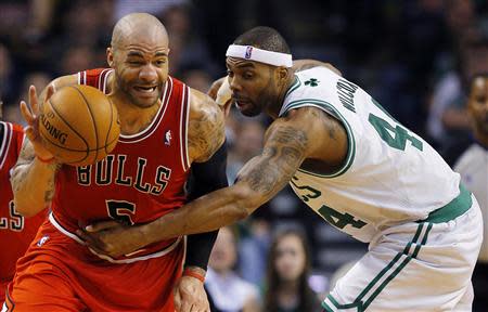 Chicago Bulls forward Carlos Boozer (L) is fouled by Boston Celtics forward Chris Wilcox in the second half of their NBA basketball game in Boston, Massachusetts February 13, 2013. REUTERS/Brian Snyder