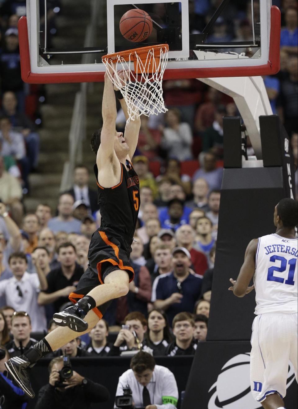 Mercer forward Daniel Coursey (52) dunks the ball against Duke forward Amile Jefferson (21) during the second half of an NCAA college basketball second-round game, Friday, March 21, 2014, in Raleigh, N.C. Mercer won 78-71. (AP Photo/Chuck Burton)