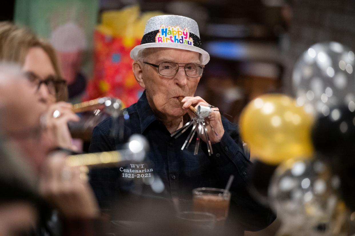 William Tollas, 100, of Evansville, blows a party horn with family during his birthday dinner at the restaurant, Little Italy, in Evansville, Ind., Tuesday evening, Nov. 2, 2021.