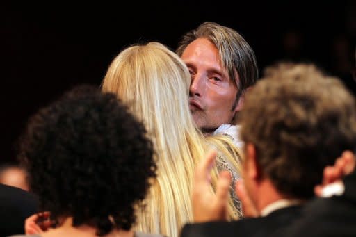 Danish actor Mads Mikkelsen (C) kisses his wife Hanne Jacobsen after he won the Best Actor award during the closing ceremony of the 65th Cannes film festival in Cannes. Cannes jury member Ewan McGregor told reporters after the awards ceremony that Mikkelsen's "performance is subtle and marvelously well played."