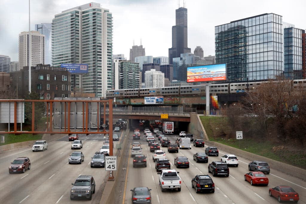 Traffic flows along Interstate 90 highway as a Metra suburban commuter train moves along an elevated track in Chicago on March 31, 2021. With upcoming data showing traffic deaths soaring, the Biden administration is steering $5 billion in federal aid to cities and localities to address the growing crisis. (AP Photo/Shafkat Anowar, File)