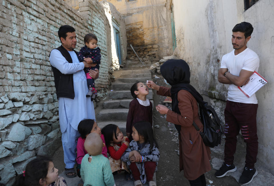 Shabana Maani, gives a polio vaccination to a child in the old part of Kabul, Afghanistan, Monday, March 29, 2021. Afghanistan is trying to inoculate millions of children against polio after pandemic lockdowns stalled the effort to eradicate the crippling disease. But the recent killing of three vaccinators points to the dangers facing the campaign as turmoil grows in the country. (AP Photo/Rahmat Gul)