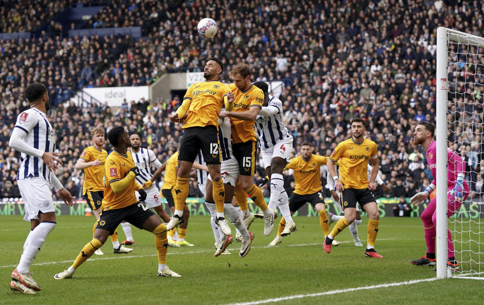 Wolverhampton Wanderers' Matheus Cunha, centre, heads clear from a corner, during the English FA Cup fourth round soccer match between West Bromwich Albion and Wolverhampton Wanderers, at The Hawthorns, in West Bromwich, England, Sunday, Jan. 28, 2024. (Bradley Collyer/PA via AP)