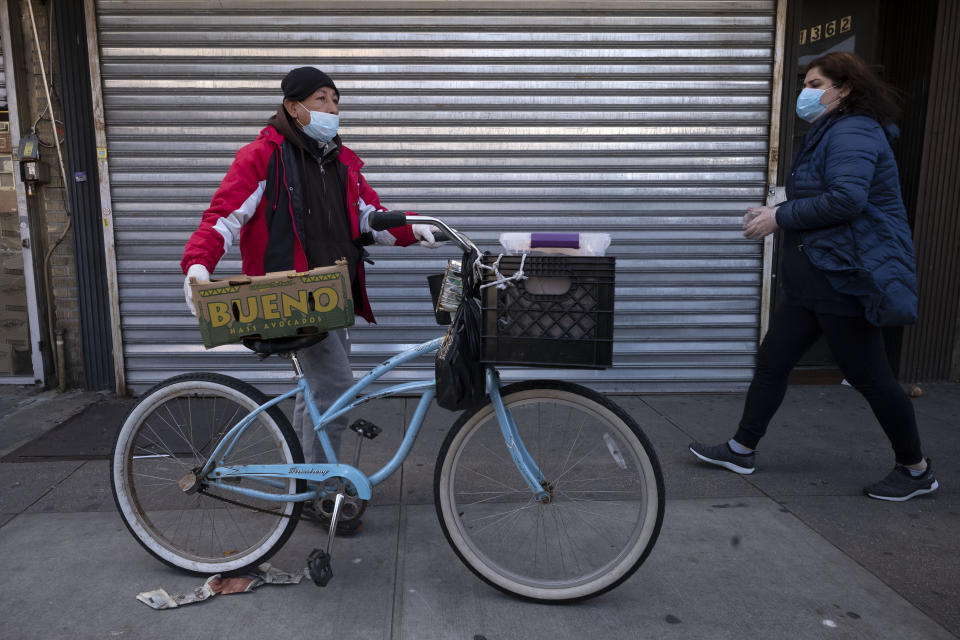 A man balances boxes of food that he picked up from Masbia Soup Kitchen, Thursday, March 26, 2020 during the coronavirus pandemic in the Brooklyn borough of New York. The new coronavirus causes mild or moderate symptoms for most people, but for some, especially older adults and people with existing health problems, it can cause more severe illness or death. (AP Photo/Mark Lennihan)