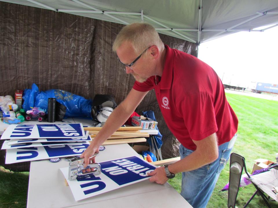 United Auto Workers Local 375 President Ron Scott Jr. stapling picket signs on Sept. 27, 2023.
