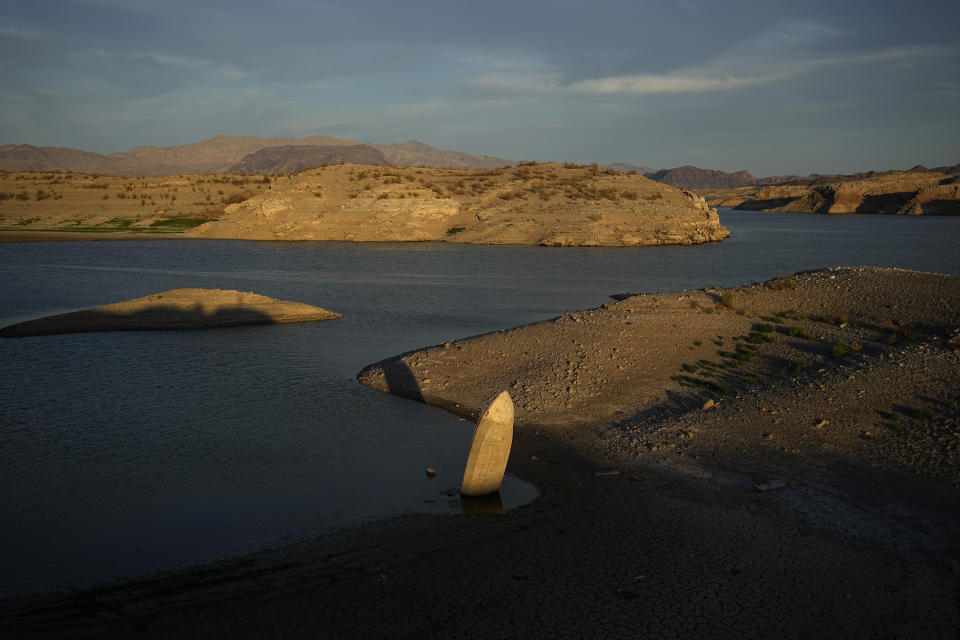 FILE - A formerly sunken boat sits upright into the air with its stern stuck in the mud along the shoreline of Lake Mead at the Lake Mead National Recreation Area on June 10, 2022, near Boulder City, Nev. Living with less water in the U.S. Southwest is the focus for a conference starting Wednesday, Dec. 14, 2022, in Las Vegas, about the drought-stricken and overpromised Colorado River. (AP Photo/John Locher, File)