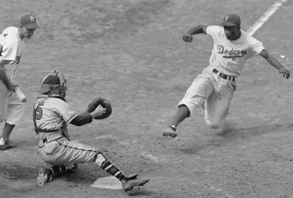 FILE - This Aug. 22, 1948 file photo shows Brooklyn Dodgers Jackie Robinson, right, stealing home plate as Boston Braves' catcher Bill Salkeld is thrown off-balance on the throw to the plate during the fifth inning at Ebbets Field in New York. With the new movie "42" bringing the Jackie Robinson story to a whole new generation, fans young and old may be interested in seeing some of the places in Brooklyn connected to the Dodger who integrated Major League Baseball. (AP Photo/File)