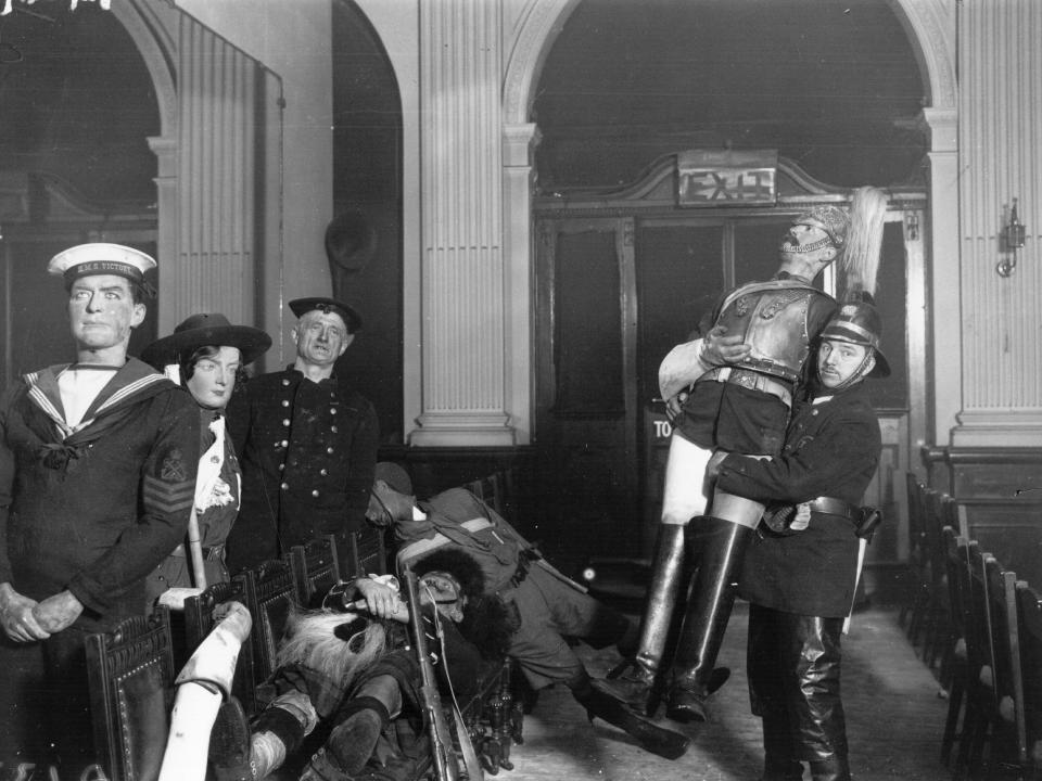 A fireman with some of the wax figures that were saved, after the fire at the famous waxworks, Madame Tussaud's in London	March 01, 1925