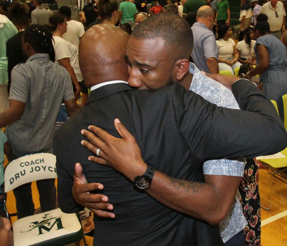 Dru Joyce II, left, is hugged by his son Dru Joyce III after the court dedication ceremony to name the court Coach Dru Joyce Court at LeBron James Arena at St. Vincent-St. Mary High School on Sunday in Akron.