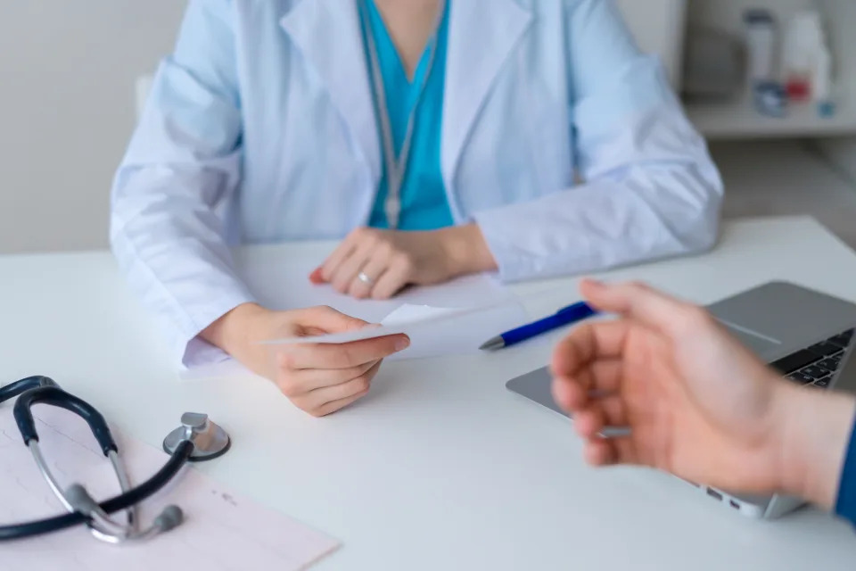 A health-care professional speaks to a patient during an appointment, like a physical or checkup, in an office. (Photo via Getty Images)