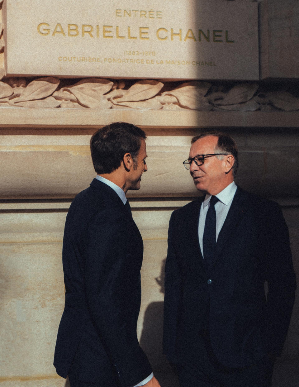 France's president Emmanuel Macron and Chanel's Bruno Pavlovsky in front of the plaque bearing the name of Gabrielle Chanel.