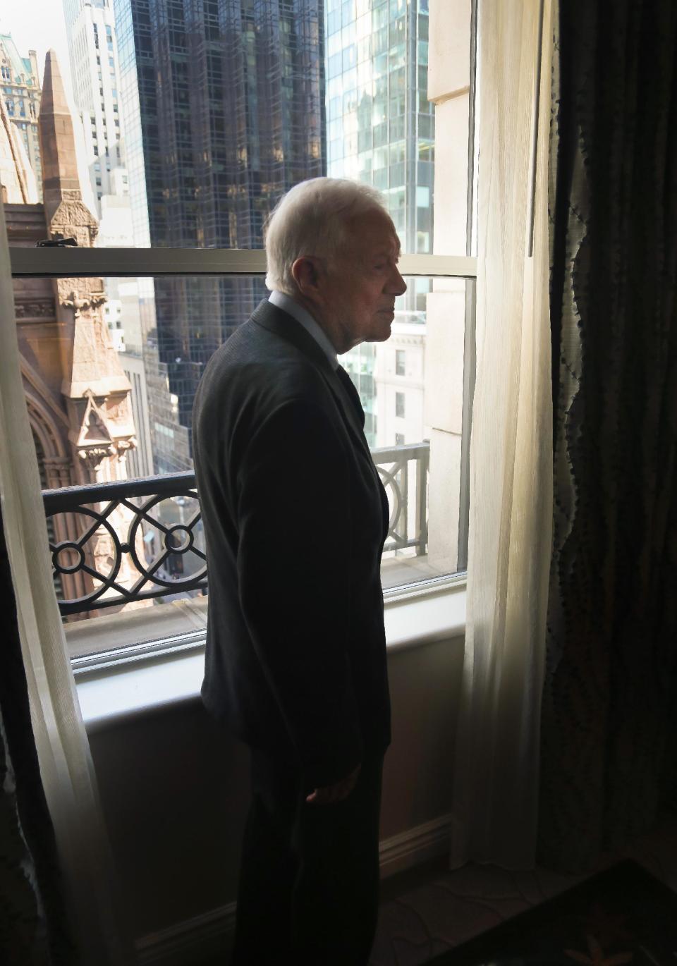 Former U.S. President Jimmy Carter pose by his hotel room window after an interview on Monday March 24, 2014 in New York. Carter says he doesn't support the Palestinian-led "boycott, divest, sanction" campaign against Israel but says products made in Israel-occupied Palestinian territories should be clearly labeled. (AP Photo/Bebeto Matthews)