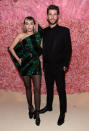 Liam Hemsworth mit Miley Cyrus, die zum grünen Paillettenkleid von Saint Laurent schwarze Tights mit Pünktchen kombiniert. (Bild: Getty Images)