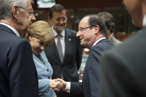 (L-R) Italian Prime Minister Mario Monti and Spanish Prime Minister Mariano Rajoy (C) look on as German Chancellor Angela Merkel and French President Francois Hollande shake hands. Hollande stepped up his crusade Thursday to convince eurozone nations to share debt between rich and poor despite resistance from Germany