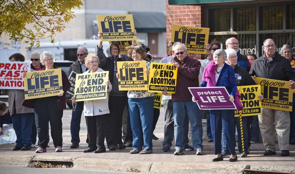 People hold signs Friday, Oct. 14, in front of the St. Cloud Planned Parenthood office on East St. Germain Street as part of the UNITED 40 Days for Life bus tour. The tour will visit more than 125 cities for the 40 Days for Life Campaign. 