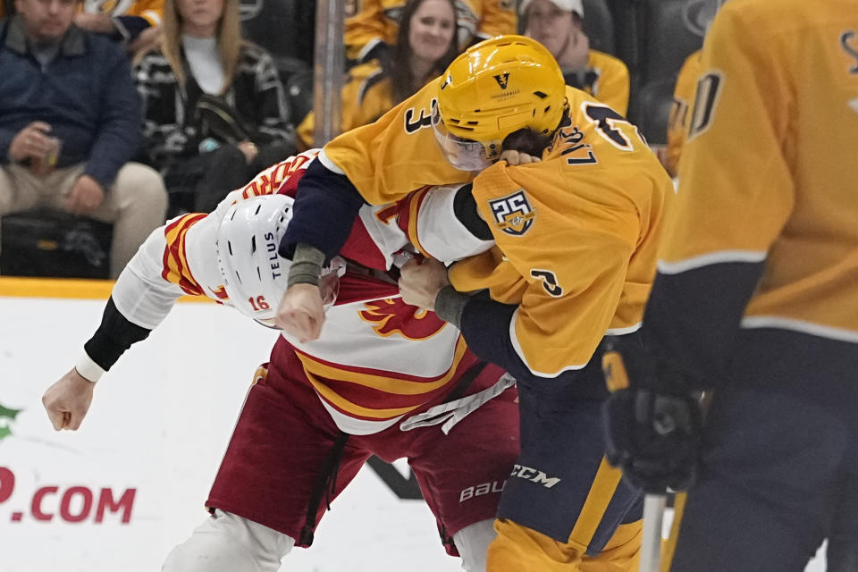 Calgary Flames defenseman Nikita Zadorov (16) and Nashville Predators defenseman Jeremy Lauzon (3) fight during the second period of an NHL hockey game Wednesday, Nov. 22, 2023, in Nashville, Tenn. (AP Photo/George Walker IV)