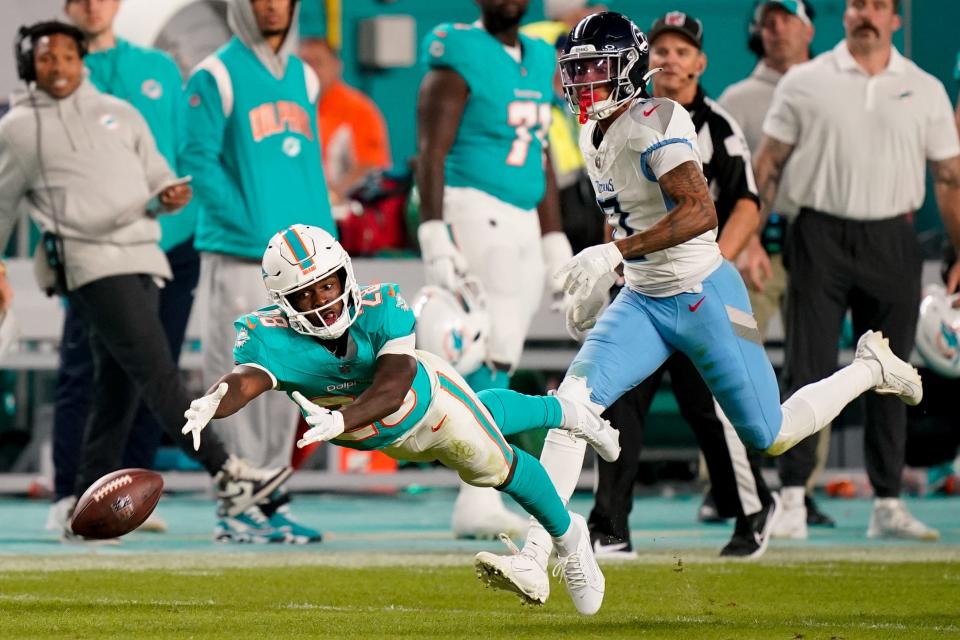Miami Dolphins running back De'Von Achane (28) comes up short of a reception past Tennessee Titans cornerback Sean Murphy-Bunting (0) during the third quarter at Hard Rock Stadium in Miami, Fla., Monday, Dec. 11, 2023.