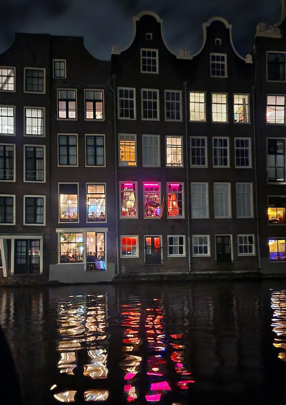 A nighttime canal cruise in Amsterdam means you can catch a glimpse of the homes along the water.