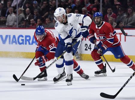 Apr 2, 2019; Montreal, Quebec, CAN; Tampa Bay Lightning forward Steven Stamkos (91) plays the puck and Montreal Canadiens forward Artturi Lehkonen (62) defends with teammate Phillip Danault (24) during the second period at the Bell Centre. Mandatory Credit: Eric Bolte-USA TODAY Sports